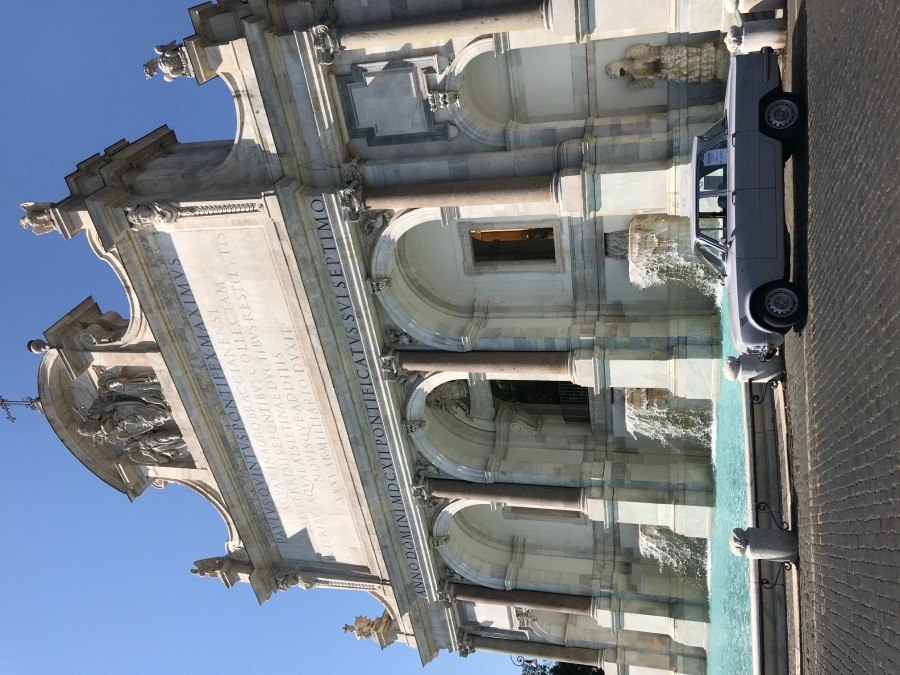 White vintage sedan parked in front of the Acqua Paola Fountain in Rome